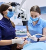 Healthcare dentistry medicine, woman doctor dentist treats teeth using dental microscope and tools. Professional modern dental equipment