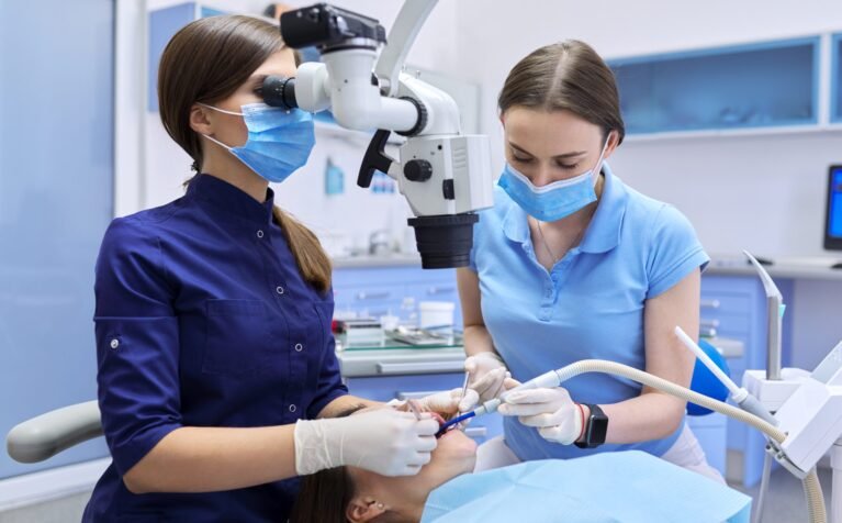 Healthcare dentistry medicine, woman doctor dentist treats teeth using dental microscope and tools. Professional modern dental equipment