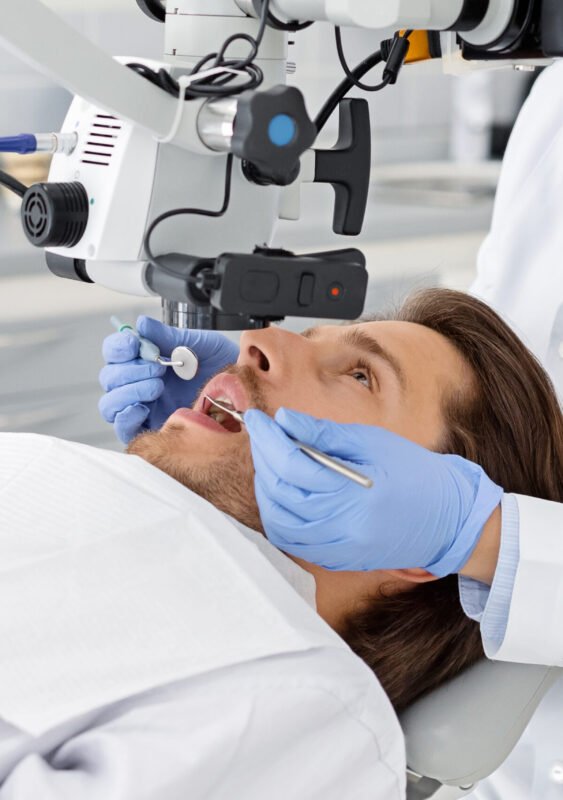 Male patient having professional dental treatment in modern cabinet, cropped
